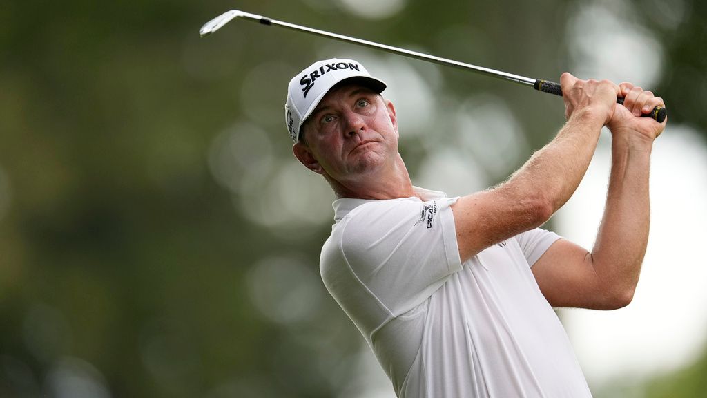 BMW Championship golfer watching his shot after a strong swing during tournament play on a wooded course.