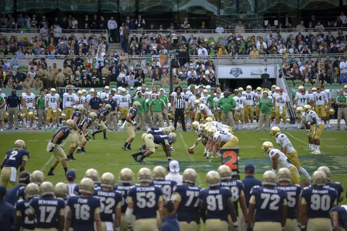 NFL Fantasy Tiers college football game with teams lined up at the line of scrimmage in front of a packed stadium.