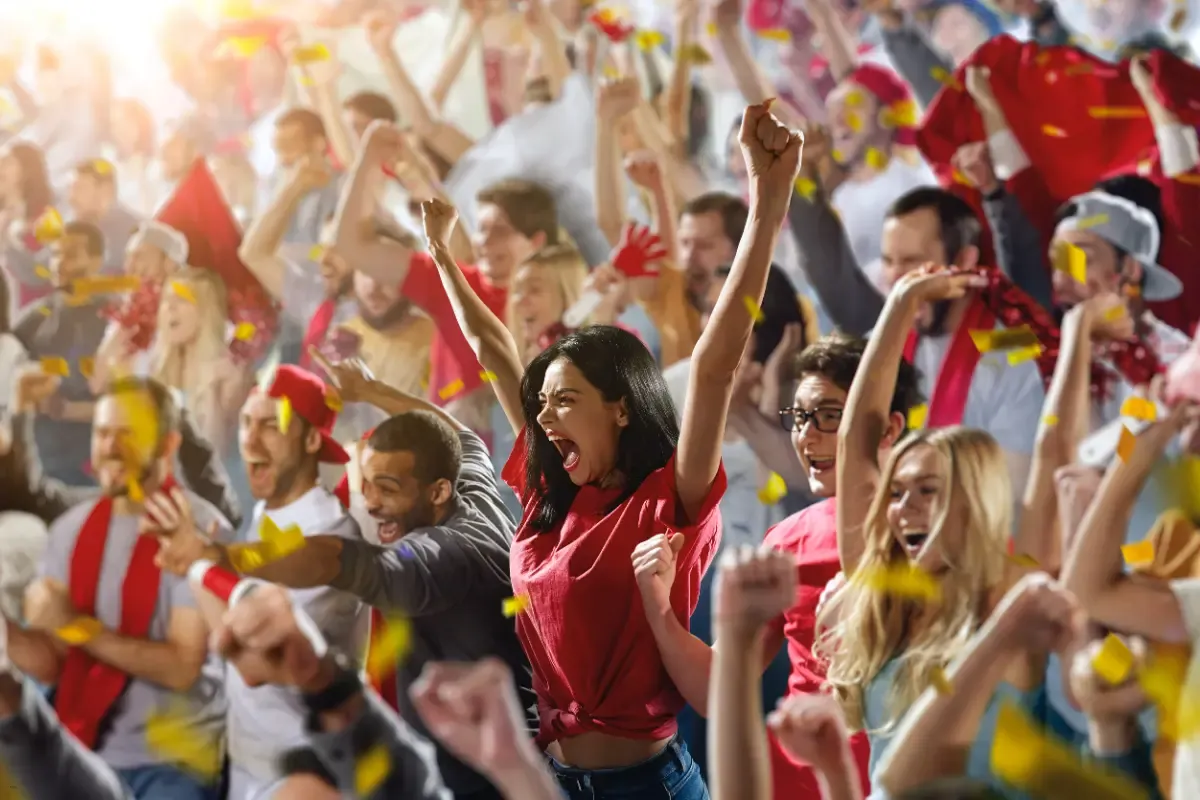 Excited crowd cheering during a sports event, symbolizing the thrill of daily fantasy sports sites