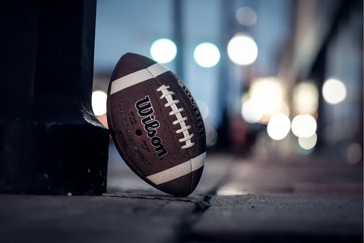 Close-up of a football resting on a sidewalk, symbolizing NFL daily fantasy anticipation