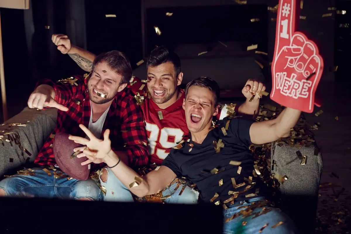 NFL playoff betting pools celebration with fans throwing confetti and cheering for their team in a thrilling moment