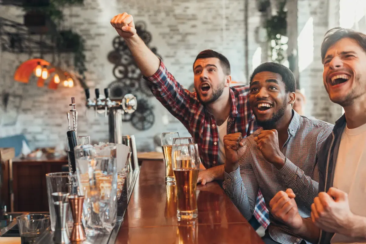 NFL playoff survivor picks excitement as friends cheer while watching a football game
