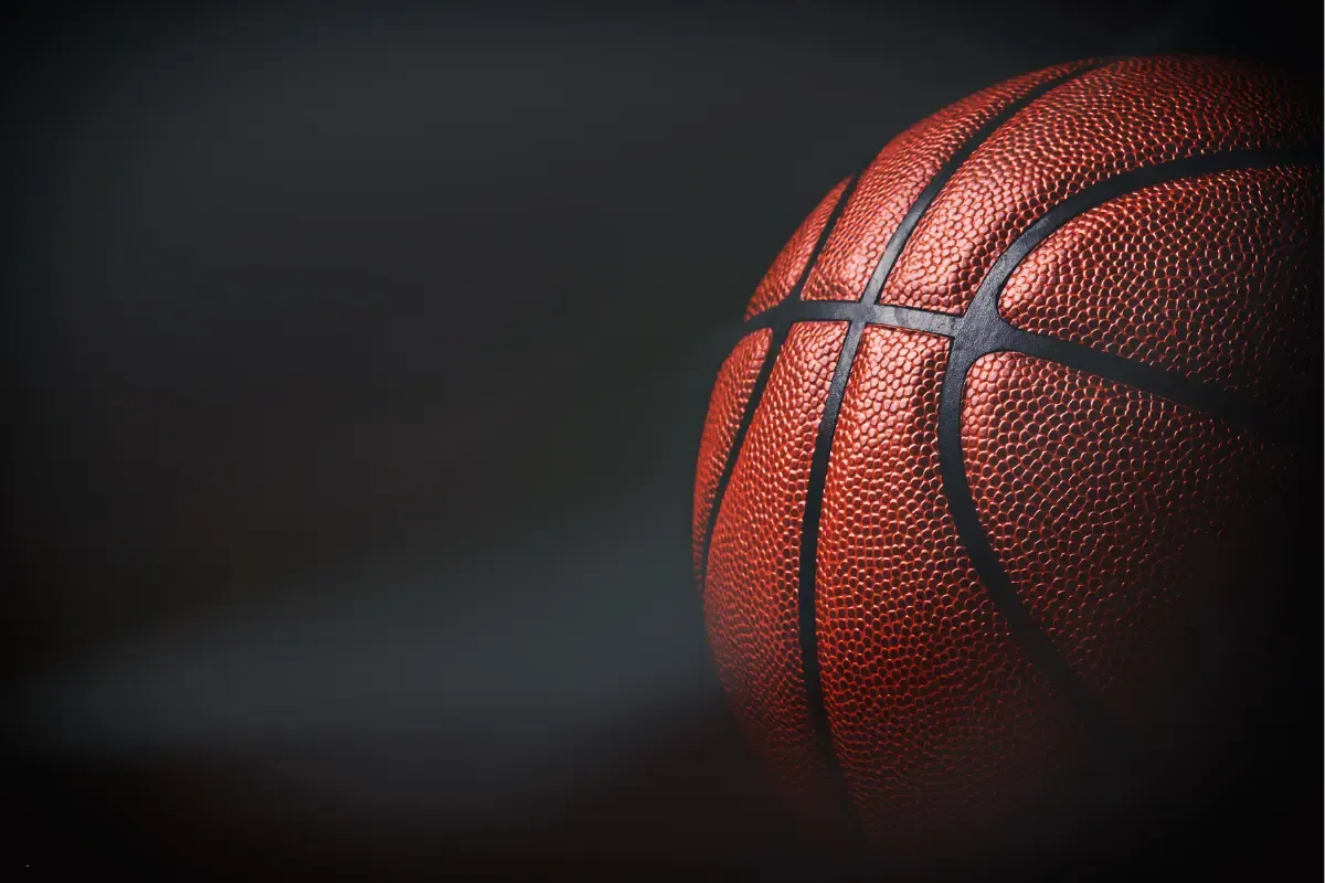 Close-up of a basketball against a dark, moody background.