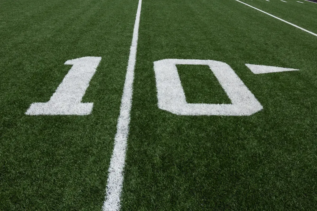View of the 10-yard line on a green football field with crisp white markings