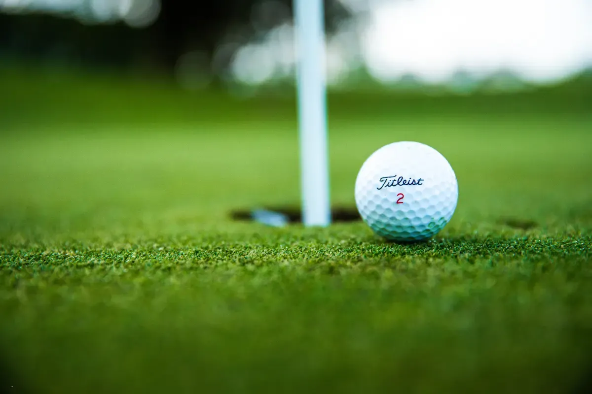 A golf ball near the hole on a putting green, ready for the final shot