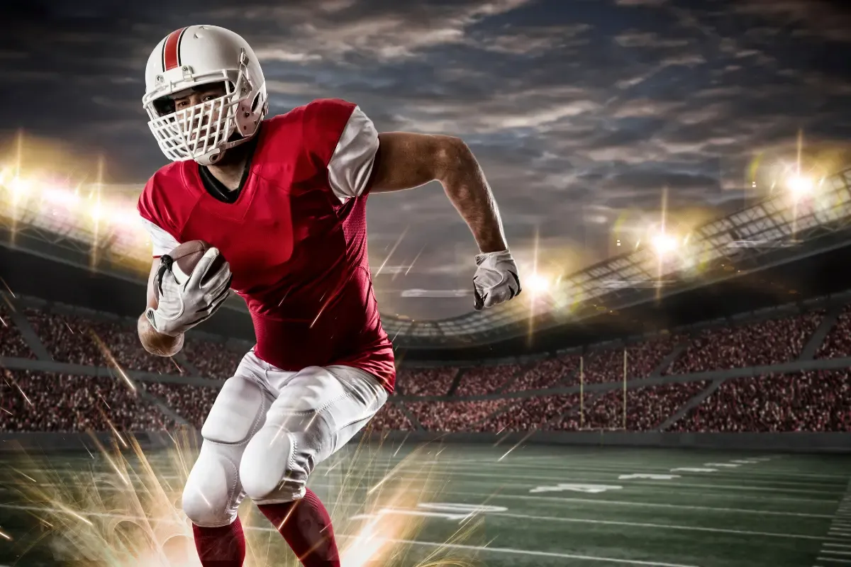 Fantasy football draft tactics displayed by a dynamic football player sprinting with the ball under stadium lights.