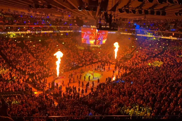 Packed basketball arena featuring pyrotechnics and team introductions