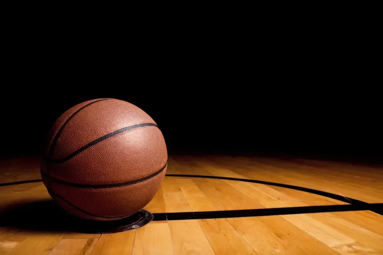 Survivor pool league tactics represented by a close-up of a basketball resting on a hardwood court.