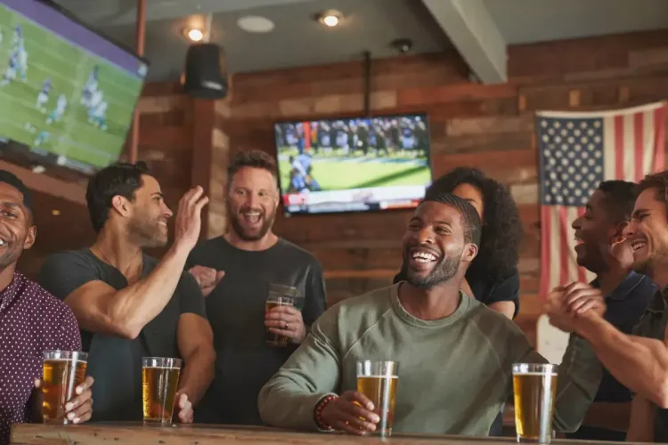 Knockout pool rules fun as a lively group celebrates touchdowns while watching a football game at a sports bar